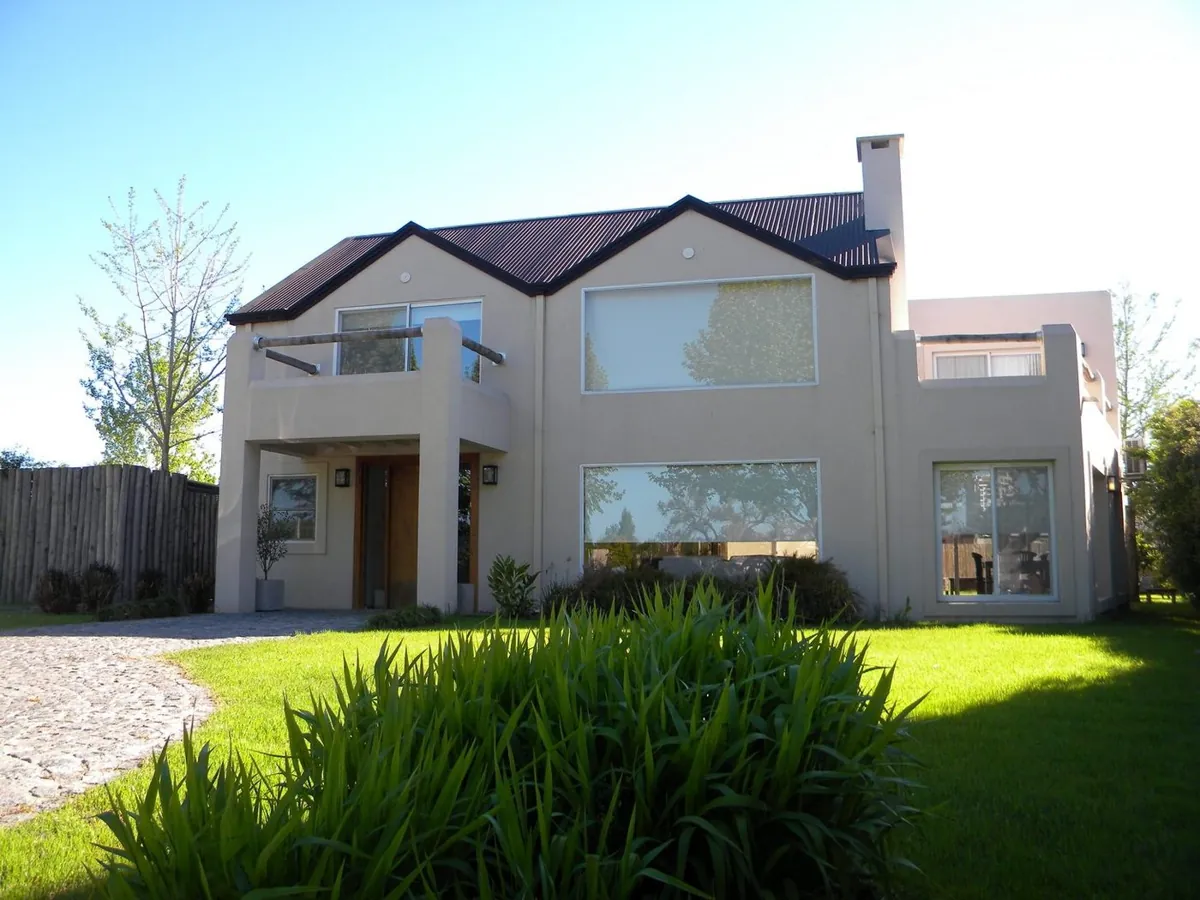 Casa con techo de tejas y jardín